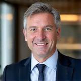 Ignas Grigas, sertifikuotas mokesčių konsultantas ir vadovaujantis partneris, šypsosi profesionalioje aplinkoje.